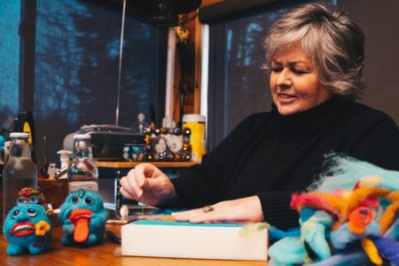 Woman felting colourful creatures